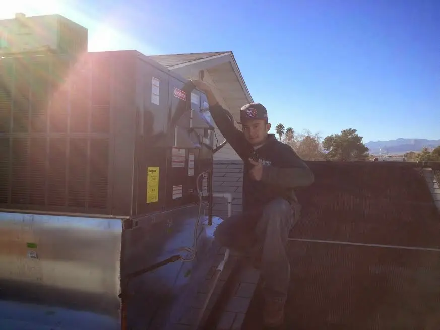 HVAC technician performing AC Tune-Up on a rooftop unit in Live Oak